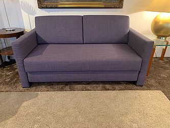 Schlafsofa Livov von Franz Fertig zum Sonderpreis mit violettem Stoffbezug