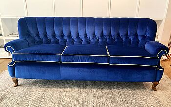 In unserer Polsterwerkstatt wurde dieses Sofa mit Rückenheftung in blauem Samt neu bezogen.  Markant istr das Andersfarbene Keder an den Sitzkissen und den Schatosen.